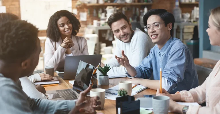 Equipa reunida à volta de uma mesa, numa conversa descontraída